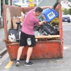A student dumps his rubbish in Clyde St in the free Skips for Students. PHOTO: PETER MCINTOSH
