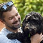 Sybil the spoodle is comforted by Dunedin man Gareth Lea after her big day out on Saturday....