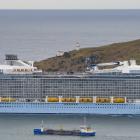 Ovation of the Seas slips between Taiaroa Head and the Port Otago dredge New Era as it entered...