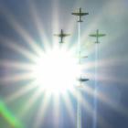 The RNZAF T-6C Texan II trainer aircraft cross the sun at the 30th Warbirds Over Wanaka air show.