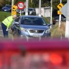 Leaving town? At a checkpoint near Pine Hill on Thursday, police stop cars to ensure their...