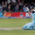 Ben Stokes of England apologises after he dives to make his ground but the ball deflects off his...