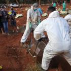 Relatives react during the burial of Geraldo Magalhaes, who died from the coronavirus disease....