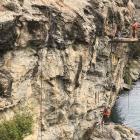 Workers pay attention to an area of cliff face in the Reilly Bluff during construction of the...