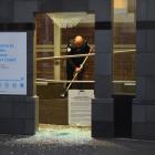 A staff member cleans up broken glass. Photo: Shawn McAvinue