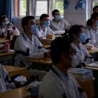Students wearing masks attend classes at a high school in Wuhan in central China's Hubei province...