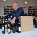 Wine Freedom co-owner Paul Williams packs a box of wine in his shop in Dunedin's Warehouse...