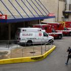 A medical worker walks past a row of ambulances parked outside of Houston Methodist Hospital as...