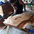 Nick Gyde stains his oak table. Photos: Supplied