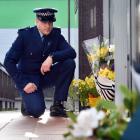 Constable Seaton McGuigan kneels at the entrance to the Dunedin police station to remember...