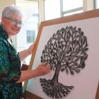 Celebrant Lynley McKerrow writes the name of a loved one on a branch of the Tree of Life. PHOTOS:...