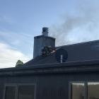 Firefighters work to put out a chimney fire in the Wrinkly Rams, Oamarama. Photo: Supplied