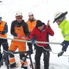 NZSki staff pull the cable taut as specialist metal rope splicer Hannes Koller thrashes the...