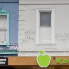 Tagging is removed from the upper storeys of George St shop yesterday afternoon. Photo: Gerard O...