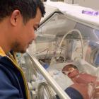 Heylon Sevilla, keeps a watchful eye on newborn daughter Estella Marie while he waits for news on...