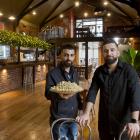 Al Sultan restaurant owner Mohammad Saad Aldeen holds some baklava while standing alongside his...