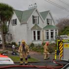 Firefighters start the cleanup process after battling a fire at a house in Oakwood Ave, Dunedin,...
