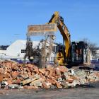 A contractor on Friday shifts rubble with an excavator to clear a site for a new 24-hour gym to...