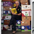 Rotary Club of Mosgiel mega book sale co-ordinator Fraser Ellis flicks through the novel Pandemic...