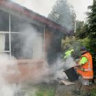 Members of the public David Thode and Jason Rosie work to bring a blaze under control that was...