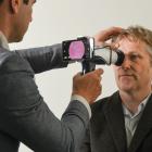 Dr Ben O’Keeffe (left) examines a patient using one of oDocs Eye Care’s devices attached to a...