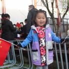 Nancy Wu (4) waves the Chinese flag during a celebration of the 71st anniversary of the founding...