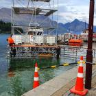 Workers in wetsuits set up a temporary structure at the Queenstown waterfront in 
...