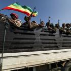 Members of Amhara region militias ride on their truck as they head to face the Tigray People's...