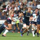 Rebels first five-eighth Matt Toomua is tackled during the side's match against the Highlanders...