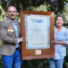 Michael Crossley and his mother Tracy hold up an honours board commemorating World War 1 and the...