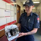 Invercargill Firefighter Tianna Newlove holds a fan heater which caught fire at a property she...