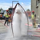 A firefighter goes through the decontamination unit after being covered in diesel. PHOTOS: LINDA...
