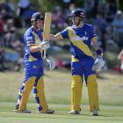 Llew Johnson acknowledges the crowd as Mitch Renwick congratulates him after he scored 50 runs...