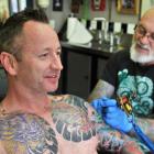 Chris Dick receives a top-up tattoo from Chris Downing, of Crazy Horse Tattoos. PHOTOS: CHRISTINE...