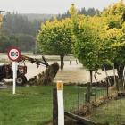 A tractor driver attempts to pull out a debris-covered fence near Pyramid Bridge after floods...