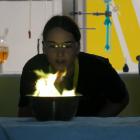 Pupil Lara Harjes (16), of Palmerston North, turns a flame green by blowing copper salt on to it....