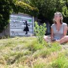 Dunedin resident Stephanie Haworth sits on a grass verge outside her Maori Hill home, which was...