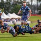 Hurricanes lock Jordie Barrett is caught in the tackle by Shannon Frizell of the Highlanders in a...