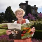 Larnach Castle owner Margaret Barker holds a copy of British magazine Country Life which features...