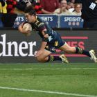Highlanders winger Connor Garden-Bachop, on debut, lunges to score a try during their opening...