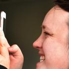 Chanelle Carter, of Waimumu, uses her Covid Tracer app in Dunedin yesterday. PHOTO: PETER MCINTOSH