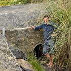 Saddle Hill Community Board chairman Scott Weatherall stands in one of the deep ditches at Ocean...