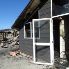 One house on a Wanaka property, pictured in the foreground, was badly damaged while the other, in...