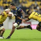 Highlanders loose forward Shannon Frizell attempts to burst through the tackles of Hurricanes...