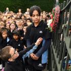 Anderson’s Bay School pupils Sidney Austin (5) and Joulia Dibo (10) place a wreath on the school...
