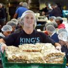 Holding some of the 44,000 individual cheese rolls made at Kings High School yesterday is pupil...