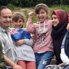 Showing off their new flag are the Haroura family, (from left) Ousama (14), Mohamad, Lina (8),...