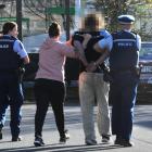 The accused is taken away by police following the incident in at Countdown in central Dunedin...