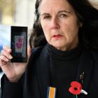  Nightcaps resident Wendy Baker’s Anzac painting (shown here on her phone) has been torn from her...