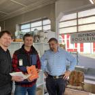 Mosgiel resident and author Athol Parks (centre) looks over copies of his bespoke hardcover book...